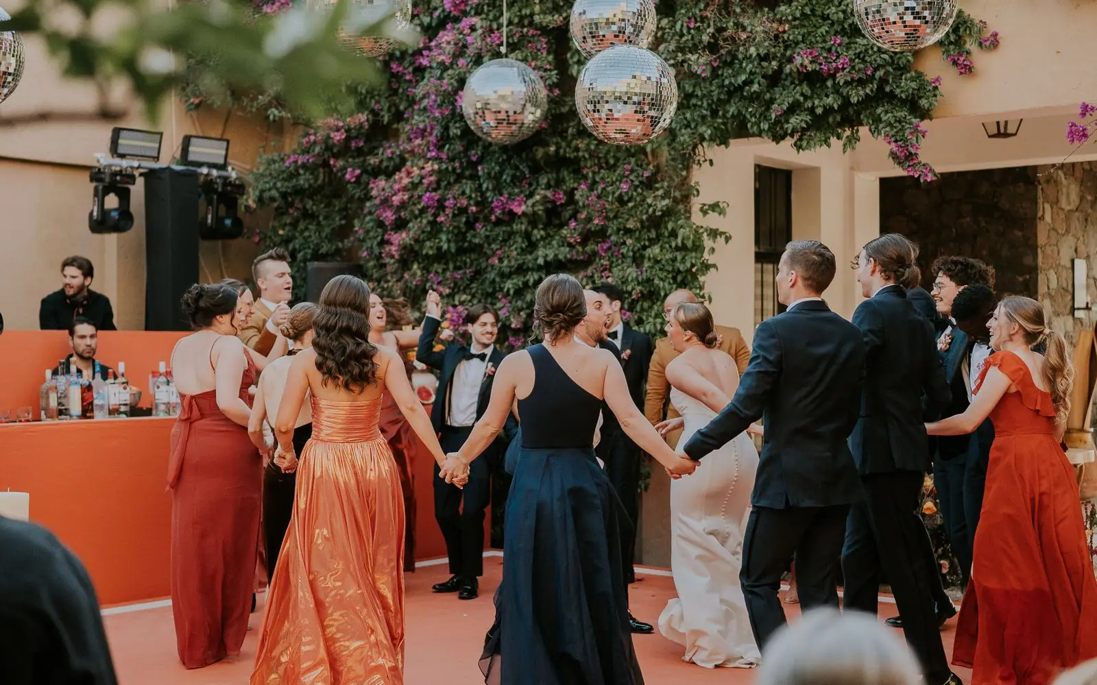 A styled mobile bar set up under string lights at an elegant outdoor evening reception